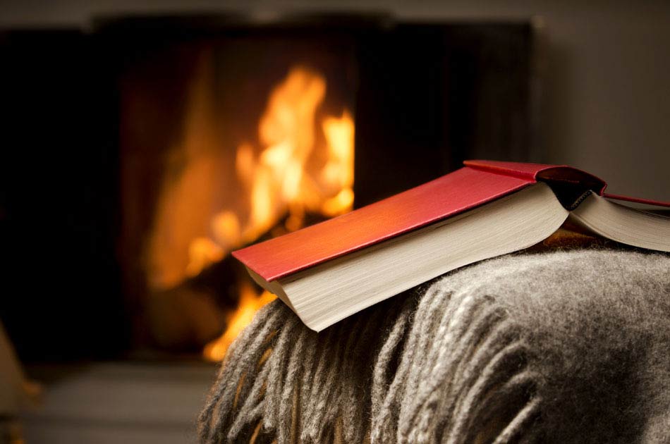 A book sits in front of the fireplace in a study