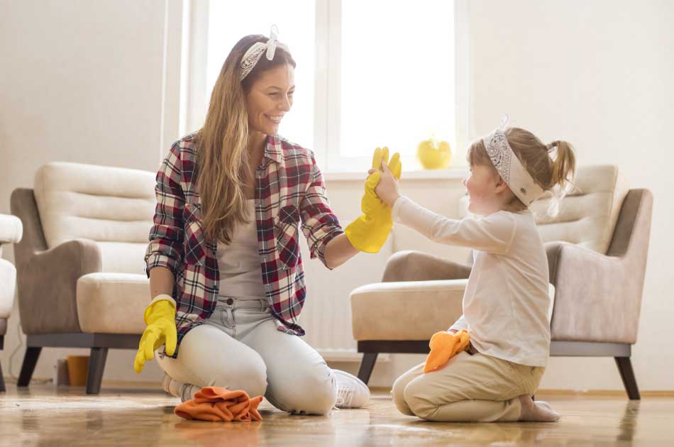 A woman and her young daughter work together spring cleaning their home